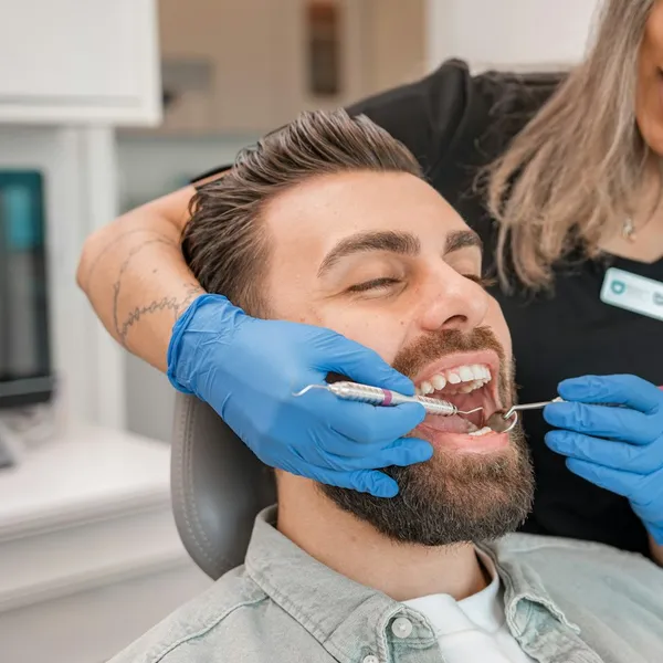 A dentist checking a man's teeth