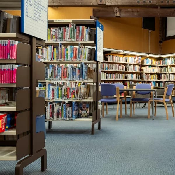 Inside a library with shelves of books and chairs